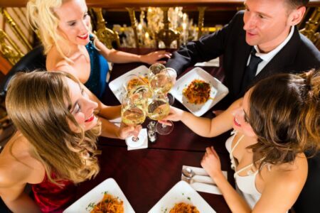 Group people sitting around table plates food