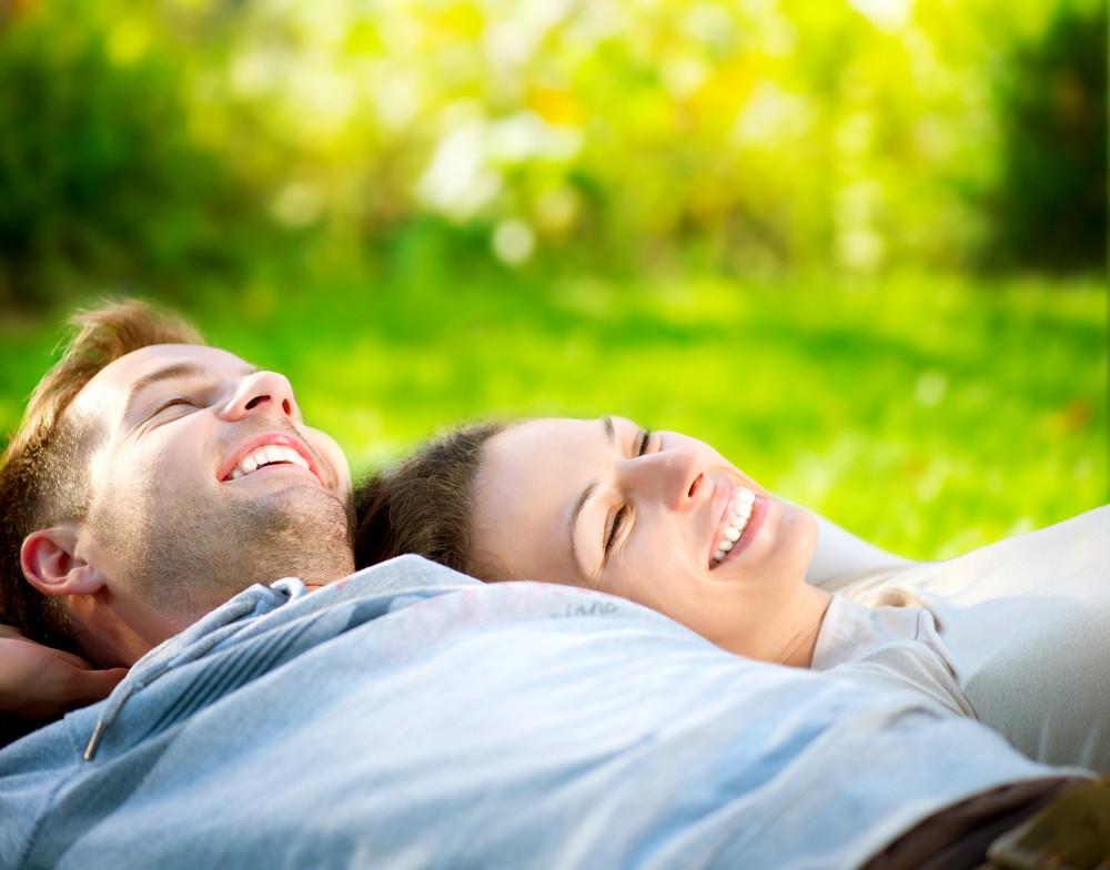 Man woman laying grass covered field